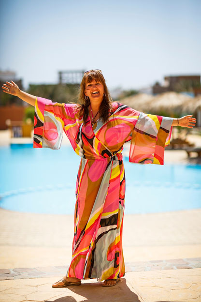 Woman in bright khaftan by the pool