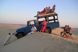 people by a jeep in the desert